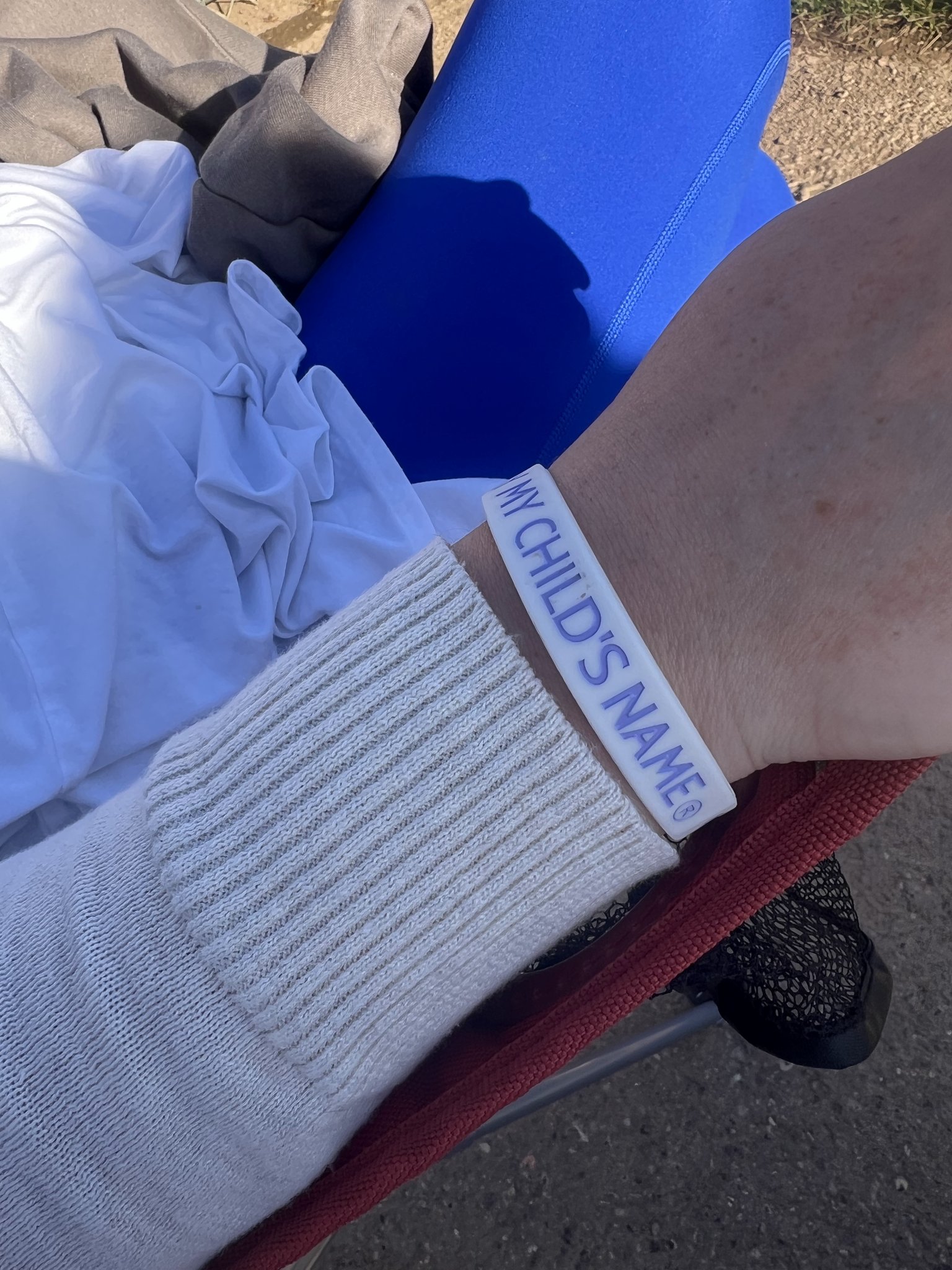 A supporter wearing a Say My Child's Name bracelet outdoors