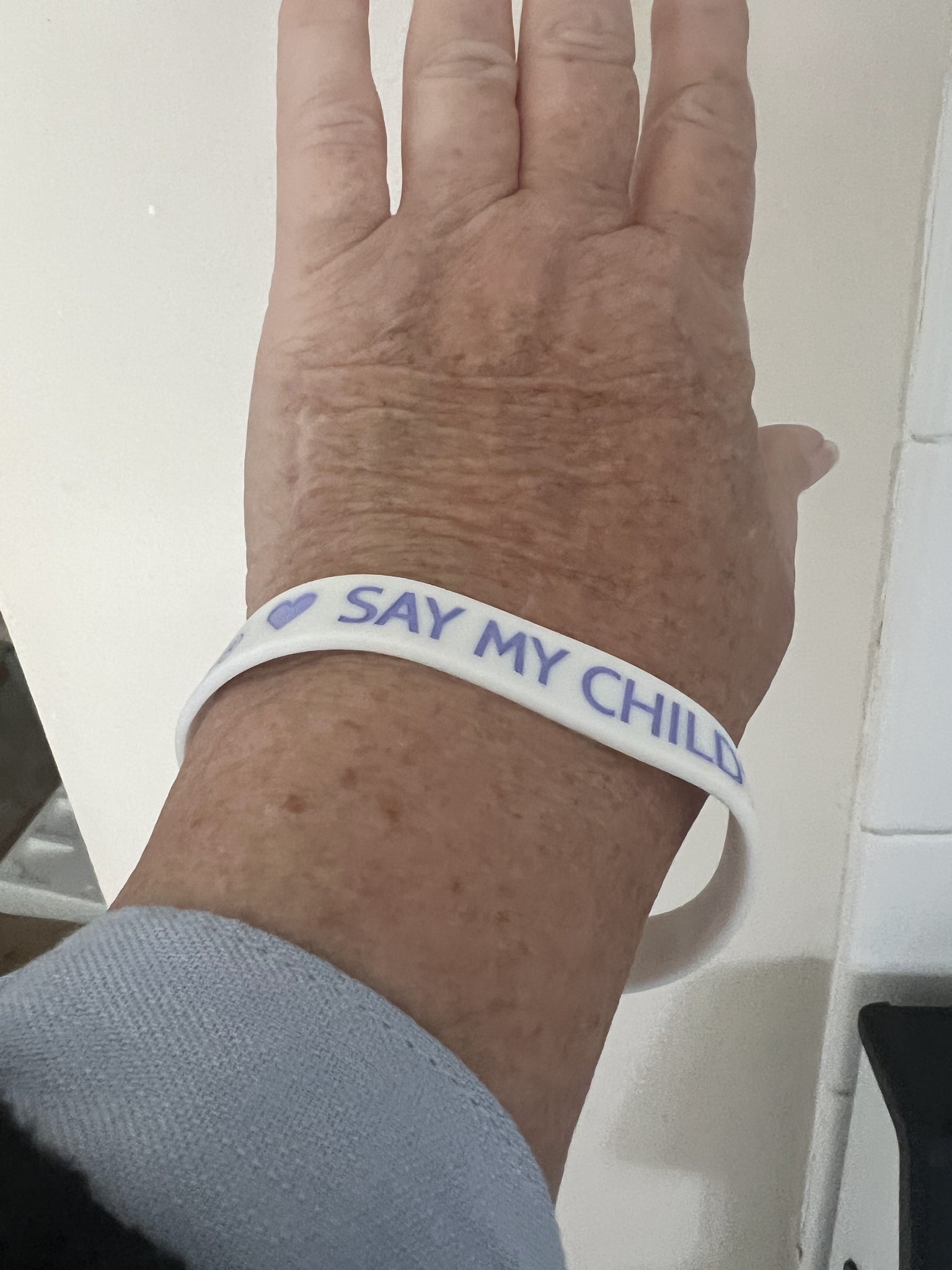A supporter displaying a Say My Child's Name bracelet